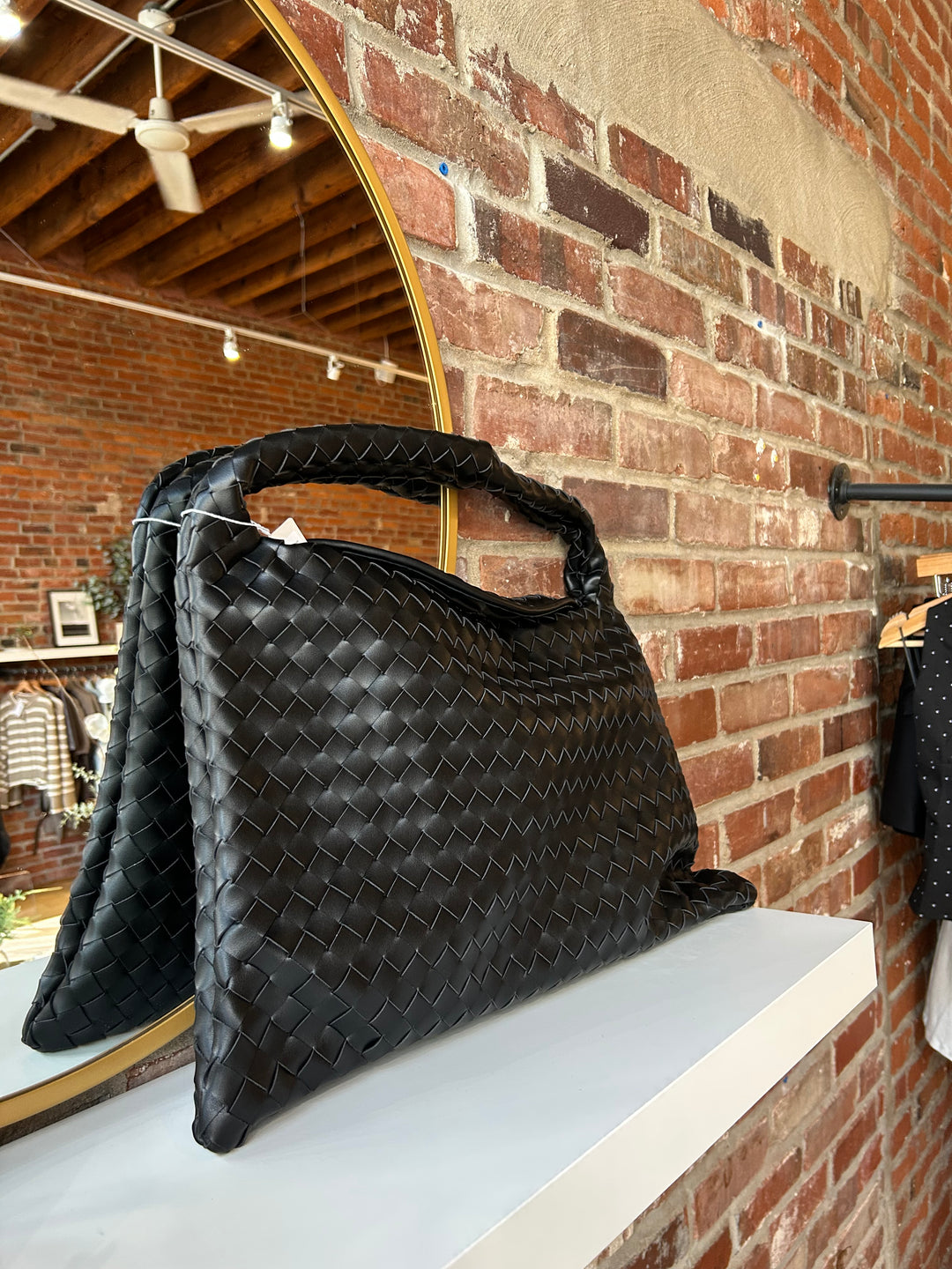 Black woven shoulder bag with magnetic closure. 