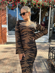 Woman wearing brown zebra print long sleeve sweater dress. 