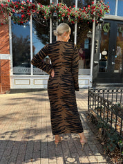 Woman wearing brown zebra print long sleeve sweater dress. 