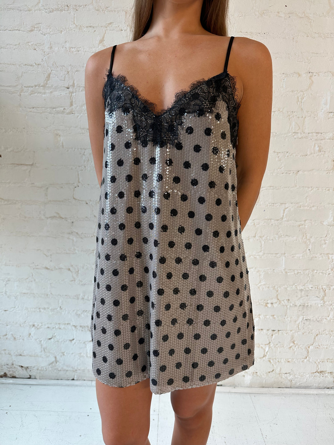 Woman wearing brown polka dot sequin shift mini dress with lace trim detail.