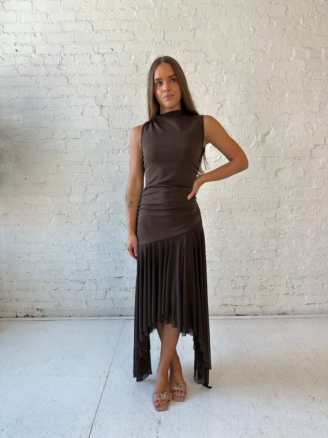 Woman wearing brown high neck maxi dress with mesh pleated bottom.