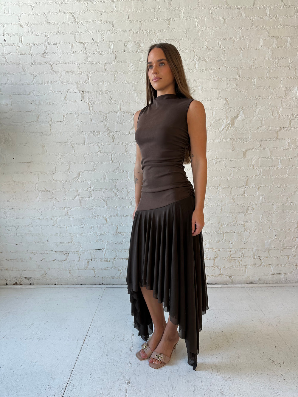 Woman wearing brown high neck maxi dress with mesh pleated bottom.