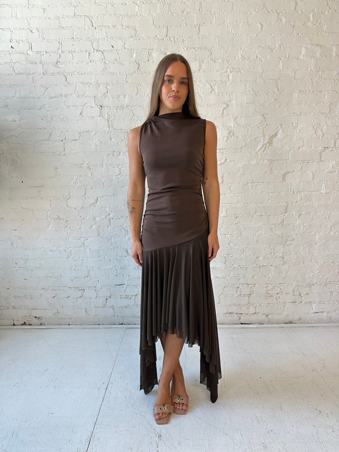 Woman wearing brown high neck maxi dress with mesh pleated bottom.