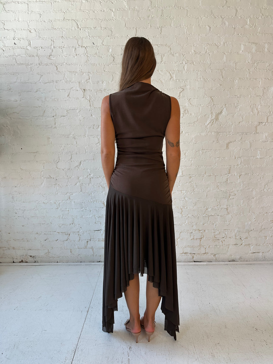 Woman wearing brown high neck maxi dress with mesh pleated bottom.
