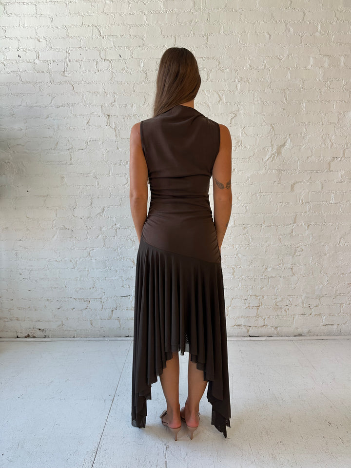 Woman wearing brown high neck maxi dress with mesh pleated bottom.