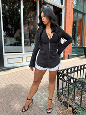 Woman wearing black long sleeve top with clasp closure. 