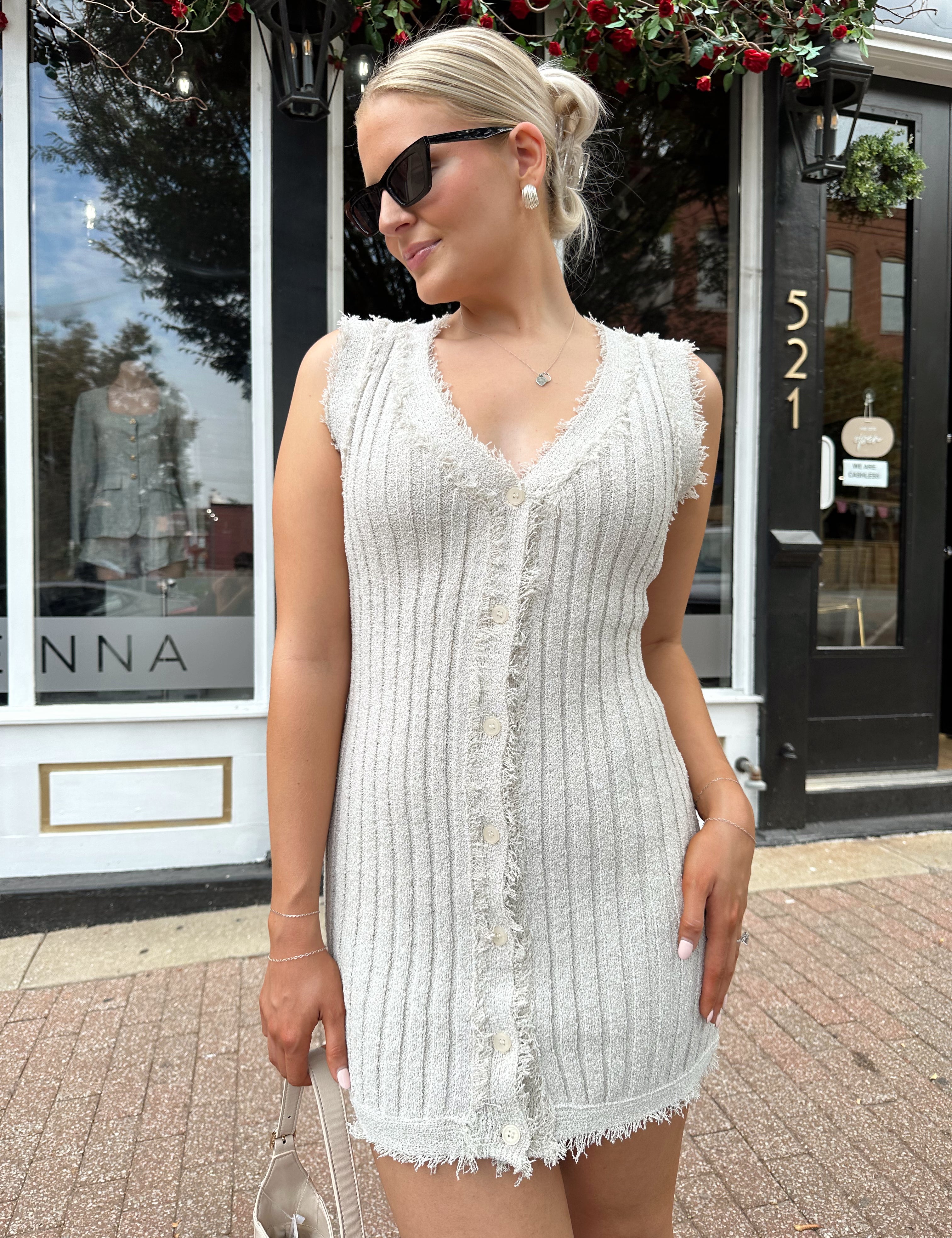Beige sweater mini dress with fringe trim and front button closure