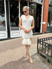 Beige sweater mini dress with fringe trim and front button closure