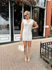 Beige sweater mini dress with fringe trim and front button closure