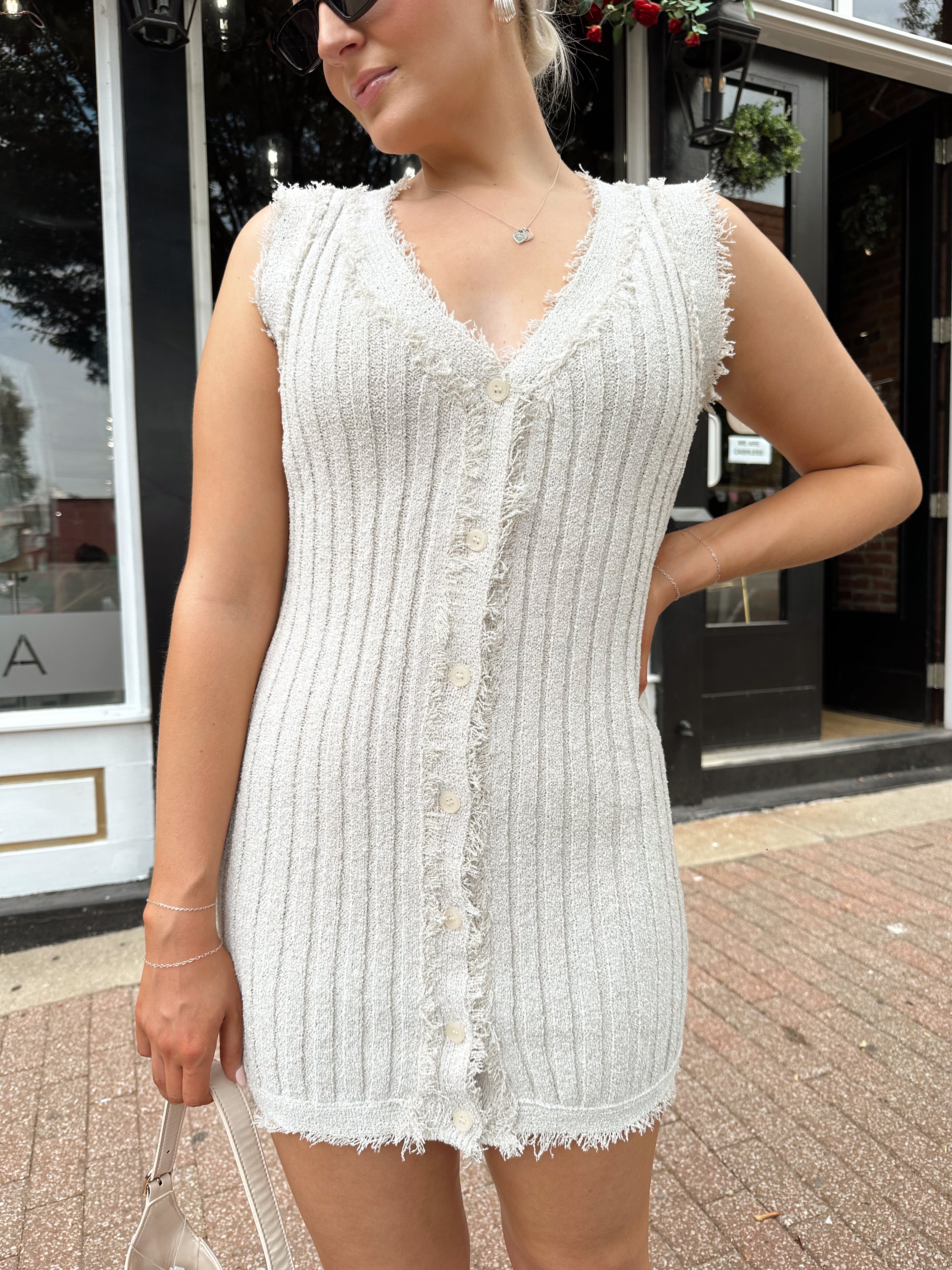 Beige sweater mini dress with fringe trim and front button closure