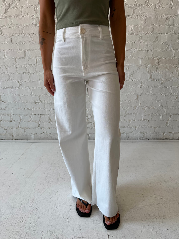 Woman wearing white high waisted wide leg jean with olive green top.