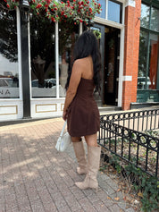 Woman wearing dark brown tailored mini dress with front pockets and built in shorts. 