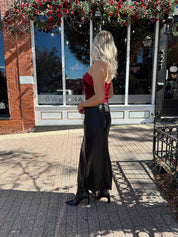 Woman wearing burgundy velvet strapless top with satin neckline. 
