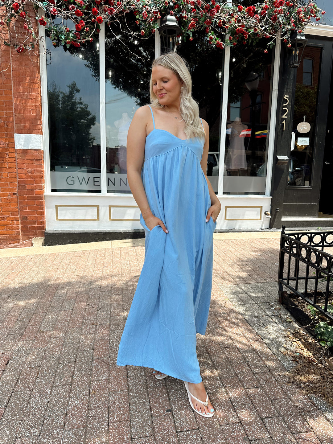 Woman wearing light blue maxi dress with sweetheart neckline and functional pockets