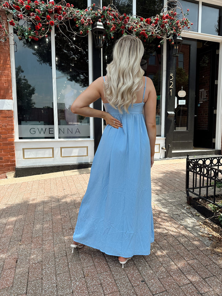 Woman wearing light blue maxi dress with sweetheart neckline and functional pockets