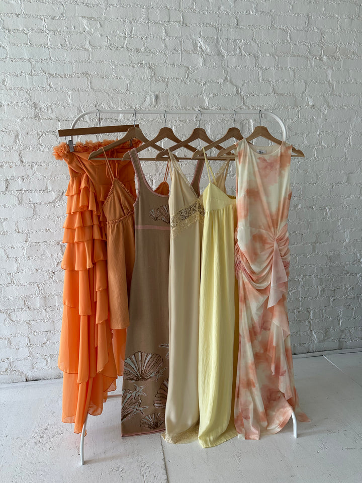 Woman wearing yellow maxi dress with sweetheart neckline, functional pockets, and adjustable straps.