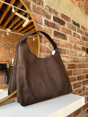 Dark brown suede shoulder bag with magnetic closure. 