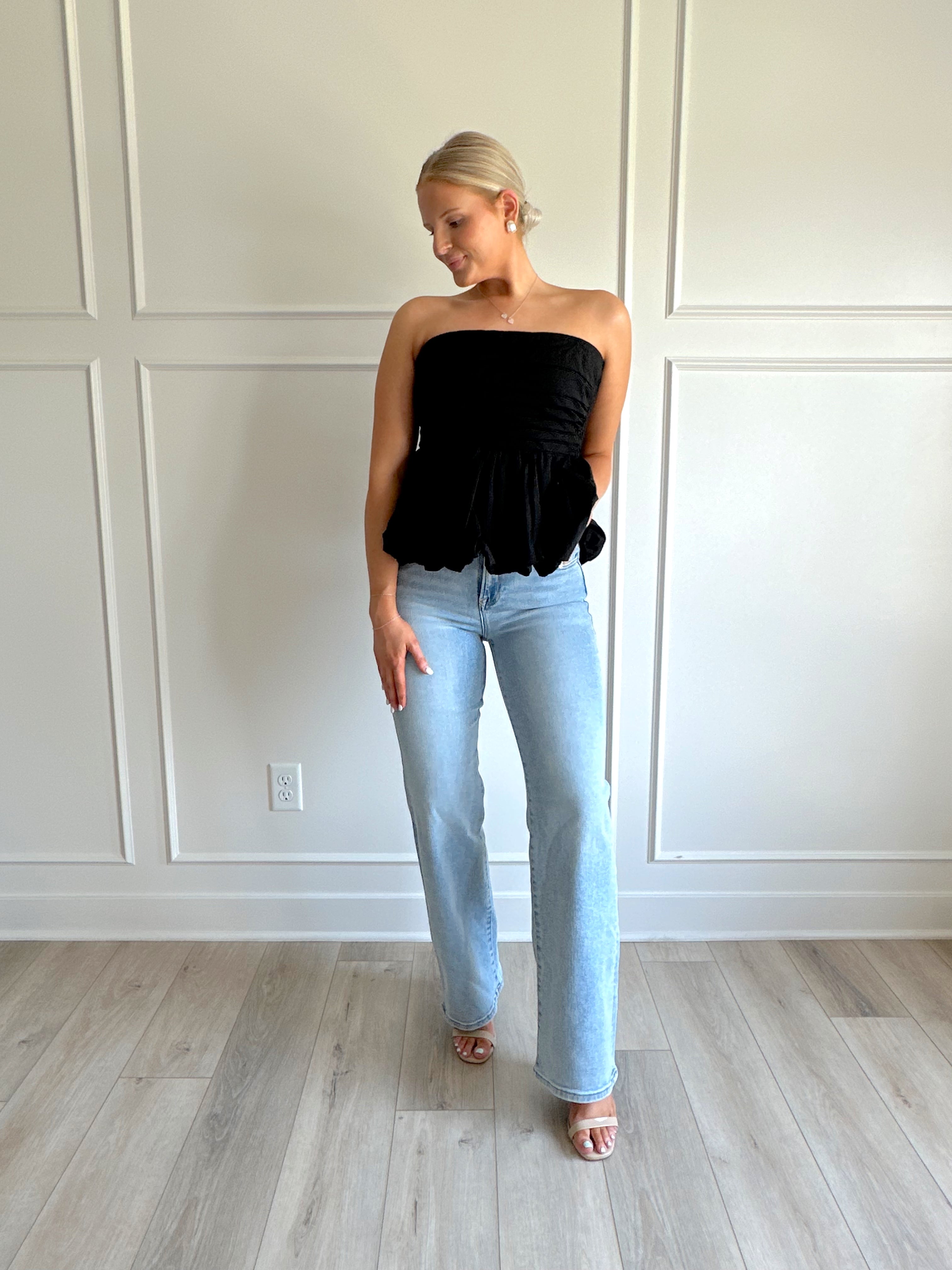 Black strapless peplum top with bubble hem.