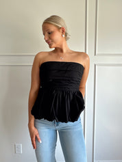 Black strapless peplum top with bubble hem.