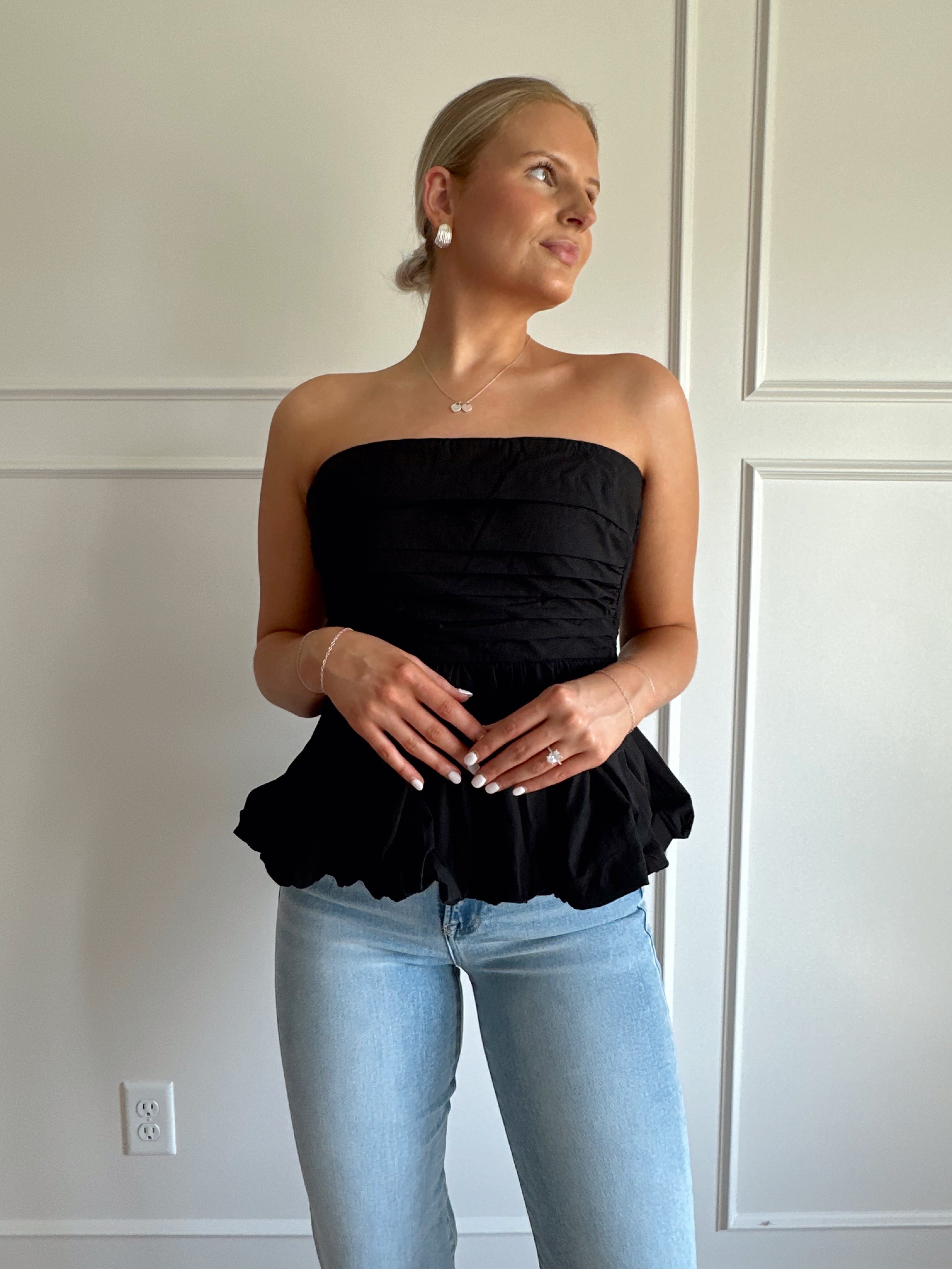 Black strapless peplum top with bubble hem.