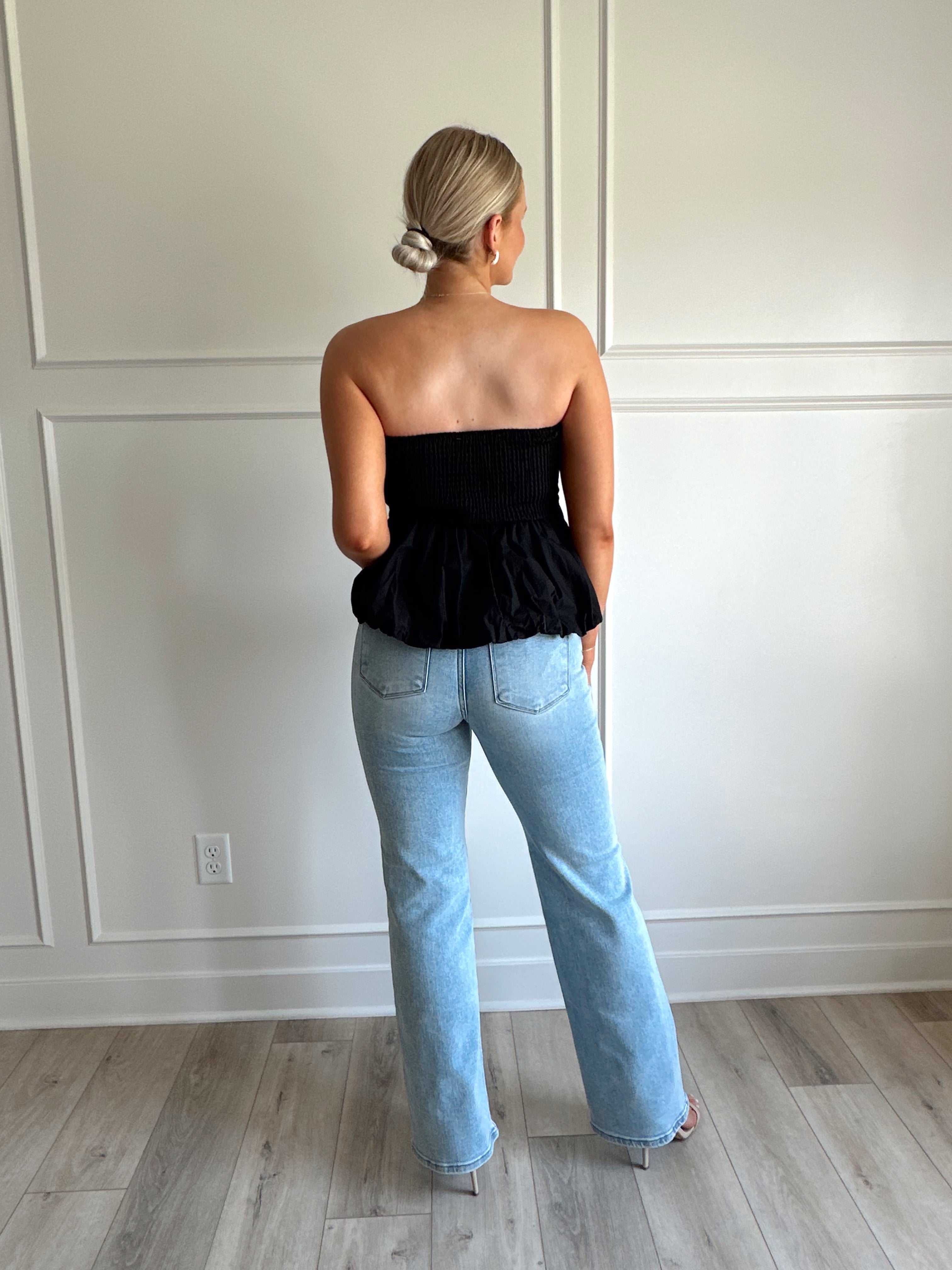 Black strapless peplum top with bubble hem.