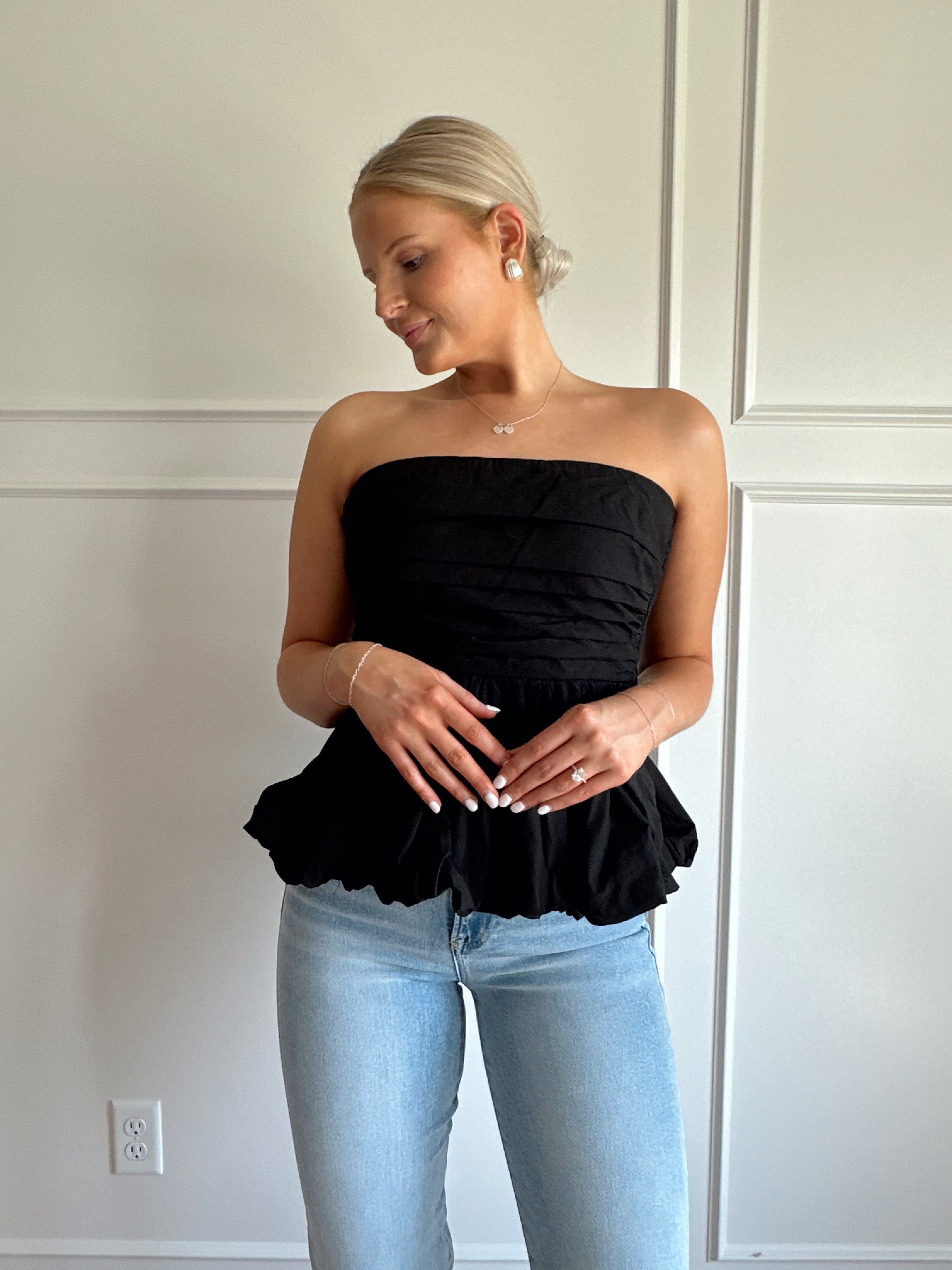 Black strapless peplum top with bubble hem.
