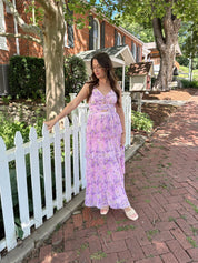 Pink pleated tiered maxi dress with a lavender floral pattern.