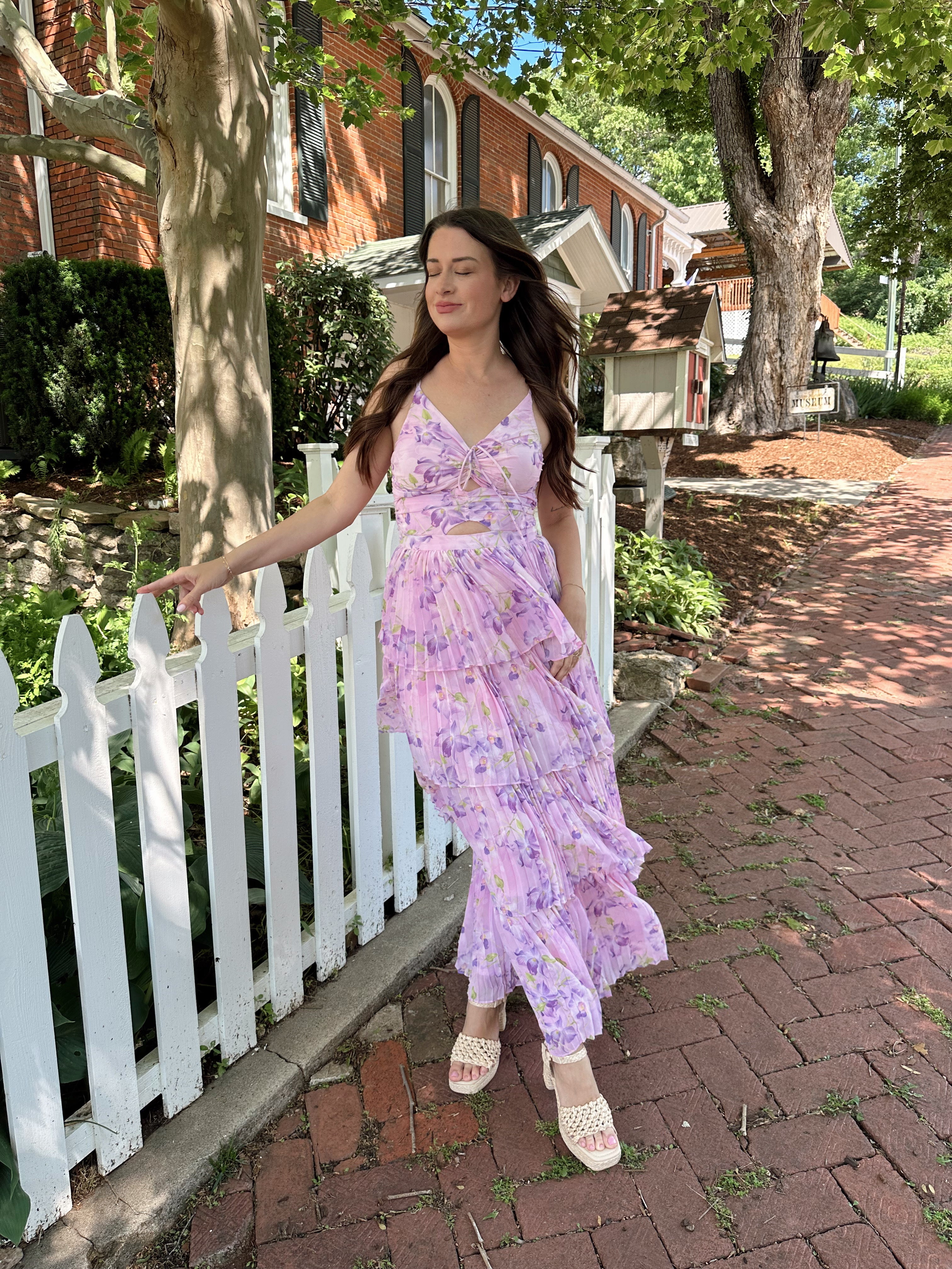 Pink pleated tiered maxi dress with a lavender floral pattern.