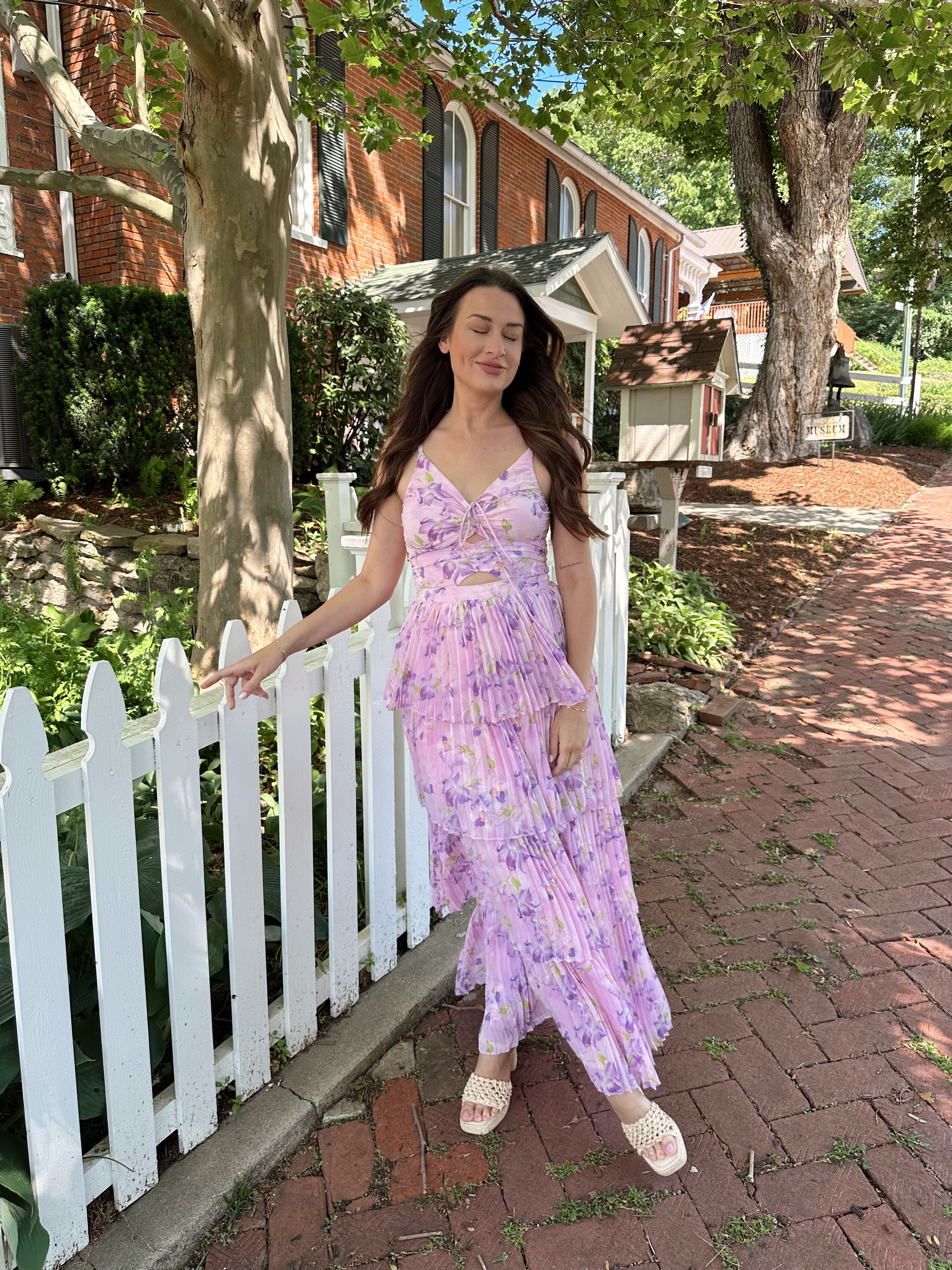 Pink pleated tiered maxi dress with a lavender floral pattern.
