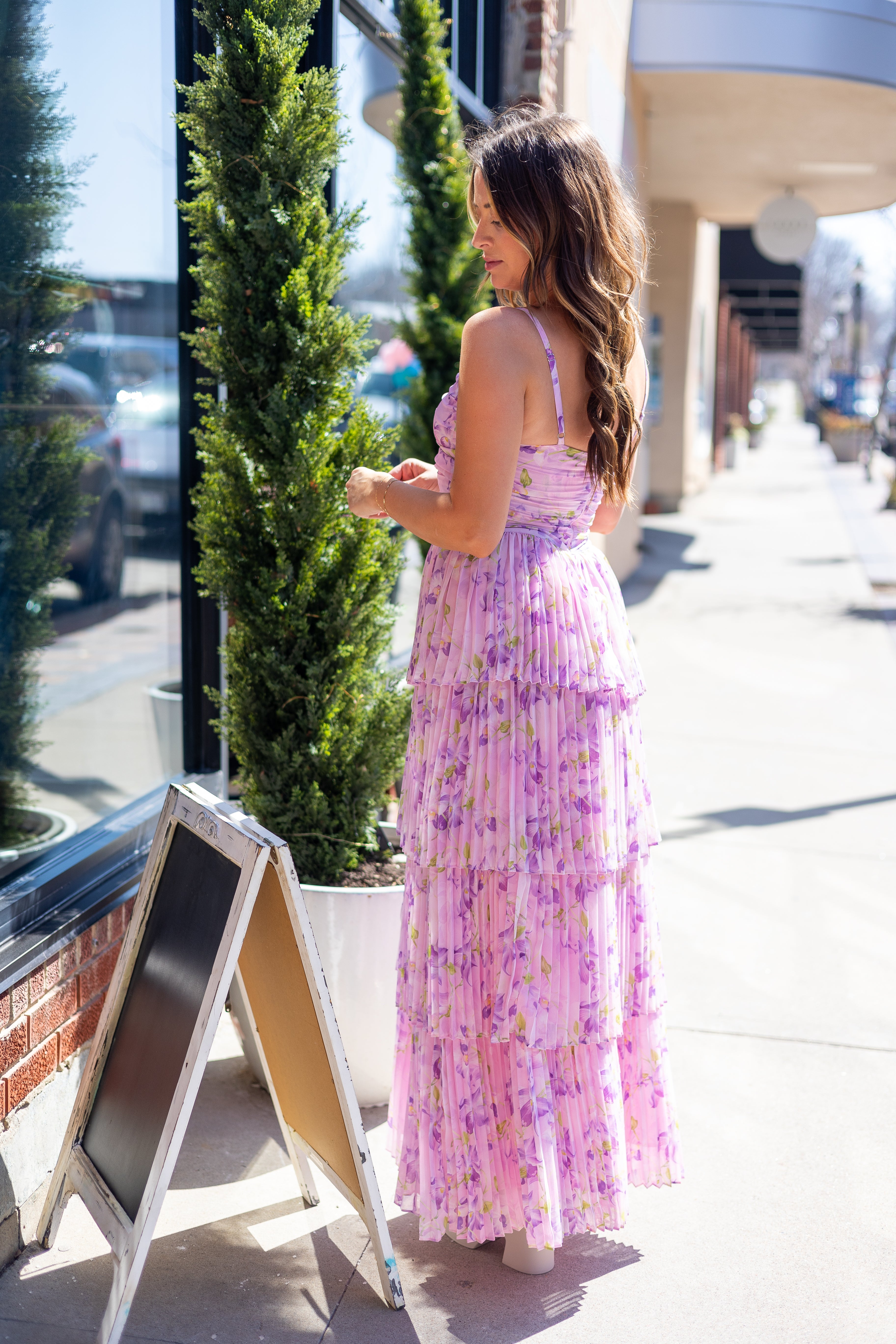 Pink pleated tiered maxi dress with a lavender floral pattern.