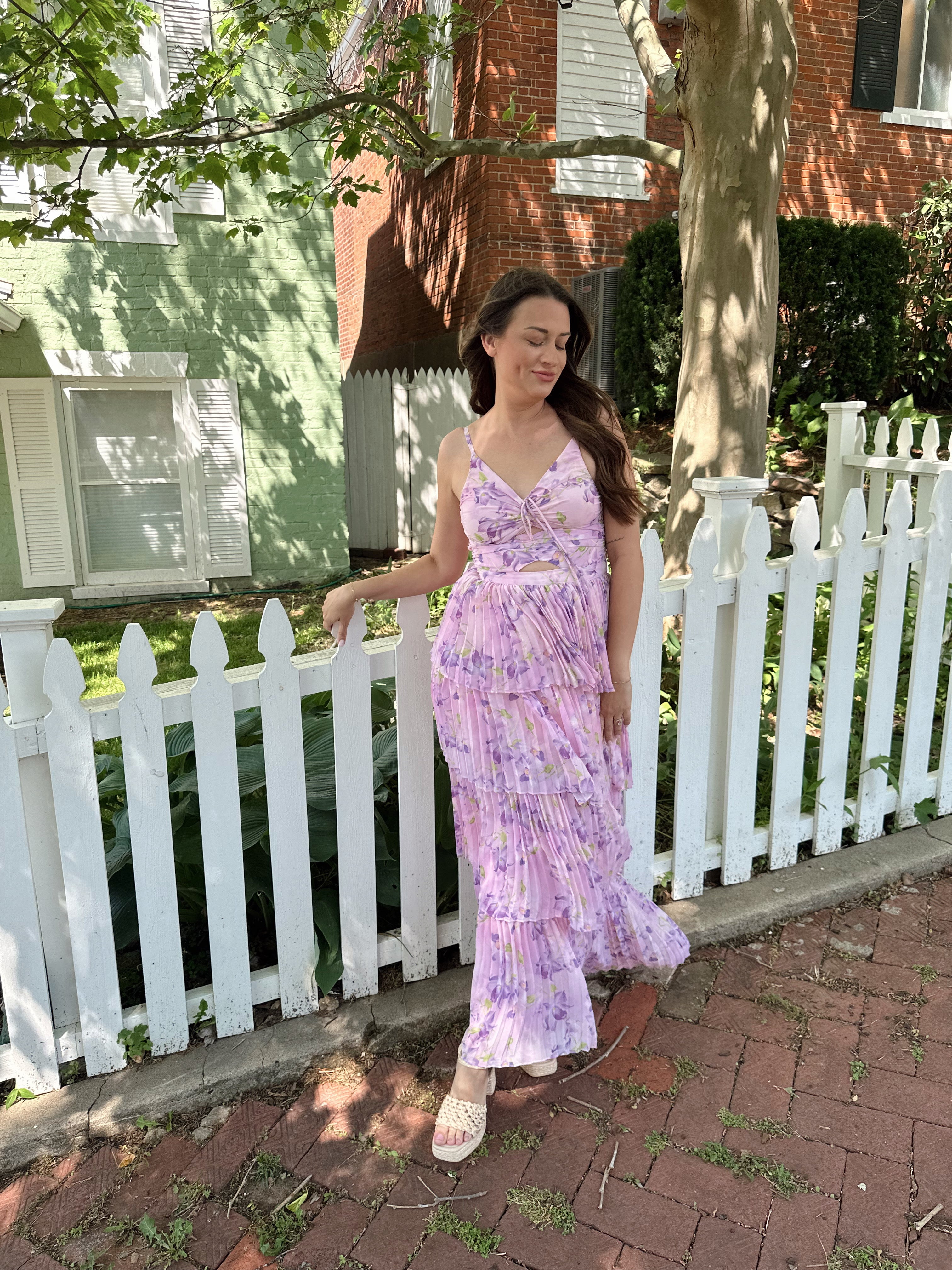 Pink pleated tiered maxi dress with a lavender floral pattern.