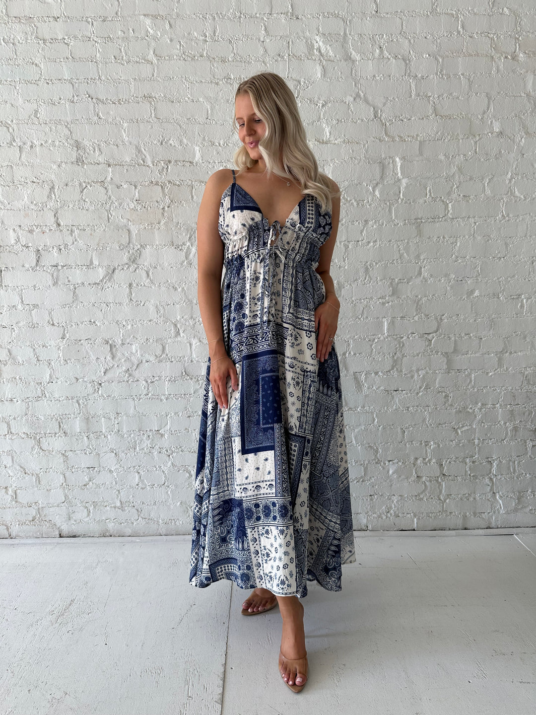 Woman wearing blue and white patchwork midi dress with adjustable straps.