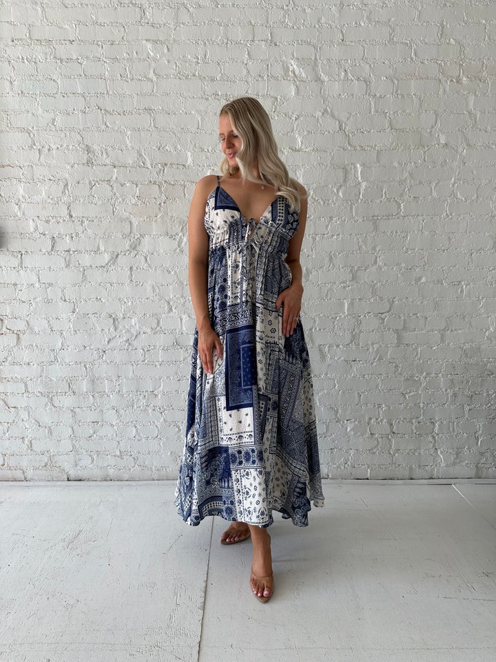 Woman wearing blue and white patchwork midi dress with adjustable straps.