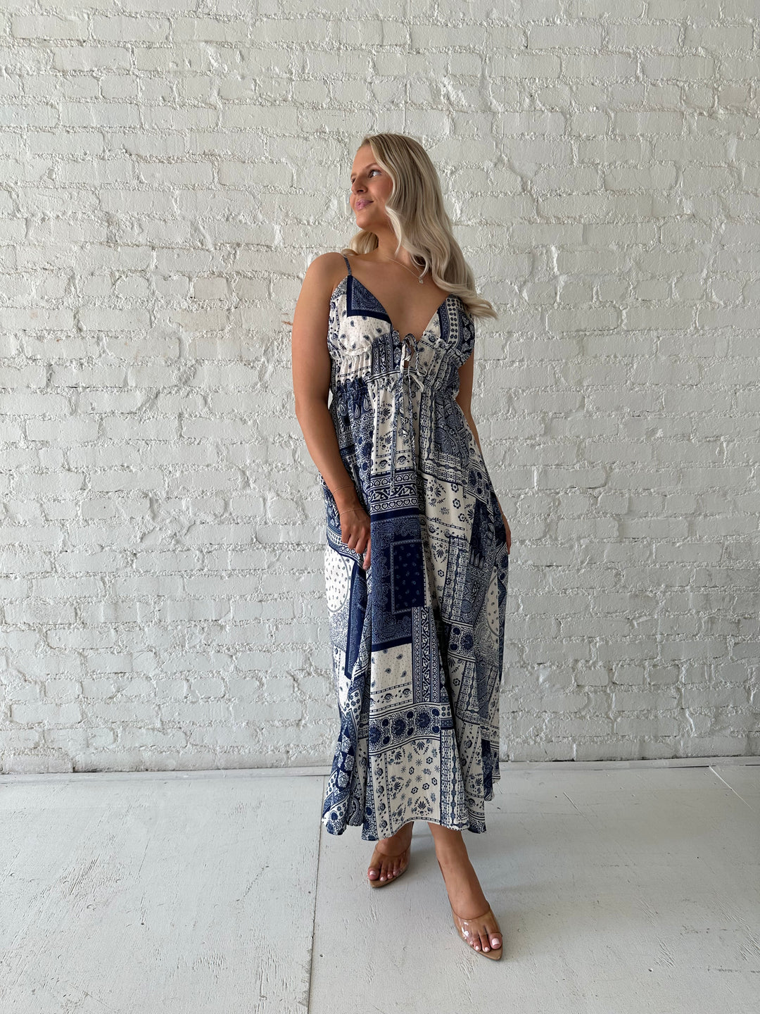 Woman wearing blue and white patchwork midi dress with adjustable straps.