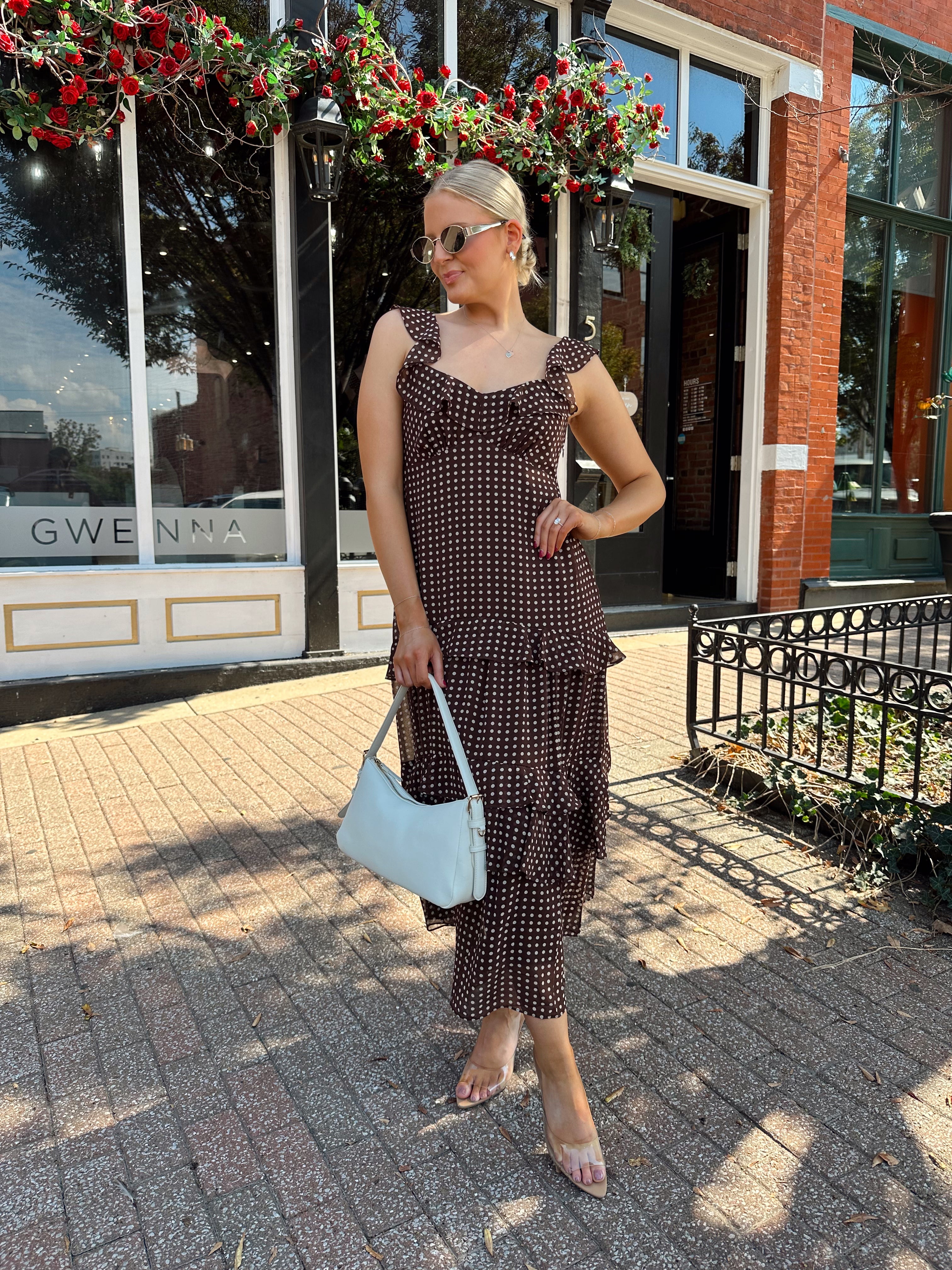 Woman wearing brown polka dot ruffle tiered midi dress. 