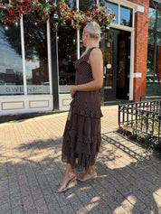 Woman wearing brown polka dot ruffle tiered mid dress. 