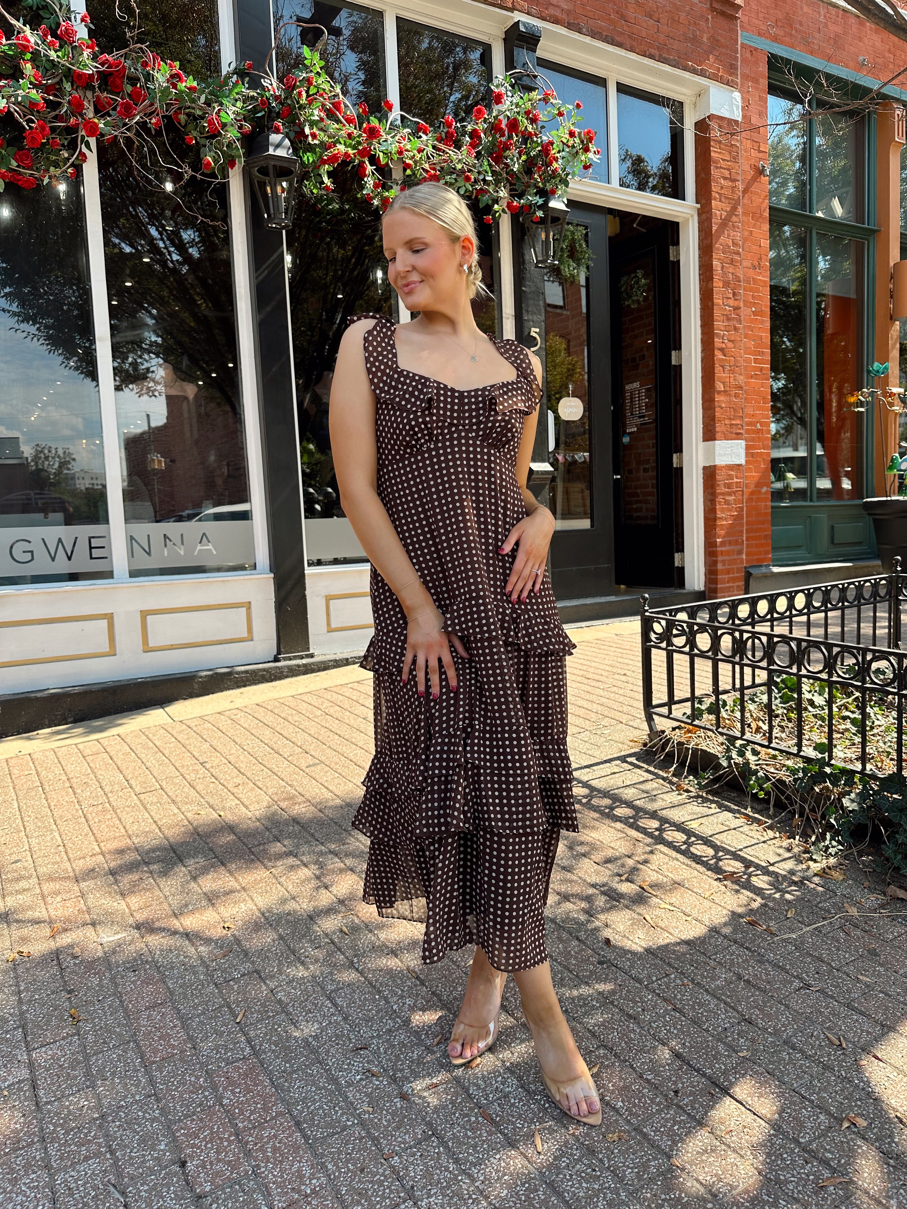 Woman wearing brown polka dot ruffle tiered midi dress. 