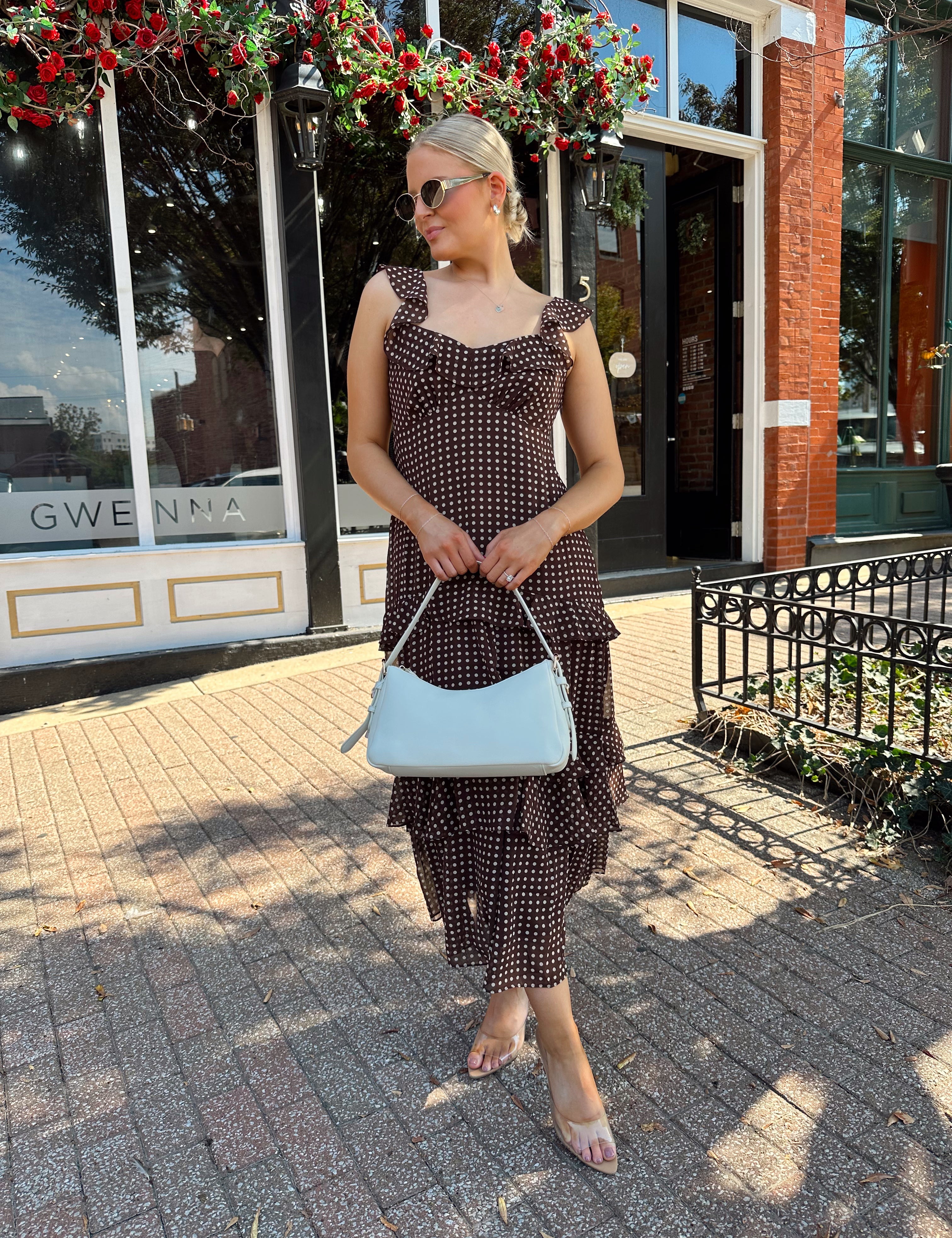 Woman wearing brown polka dot ruffle tiered midi dress. 
