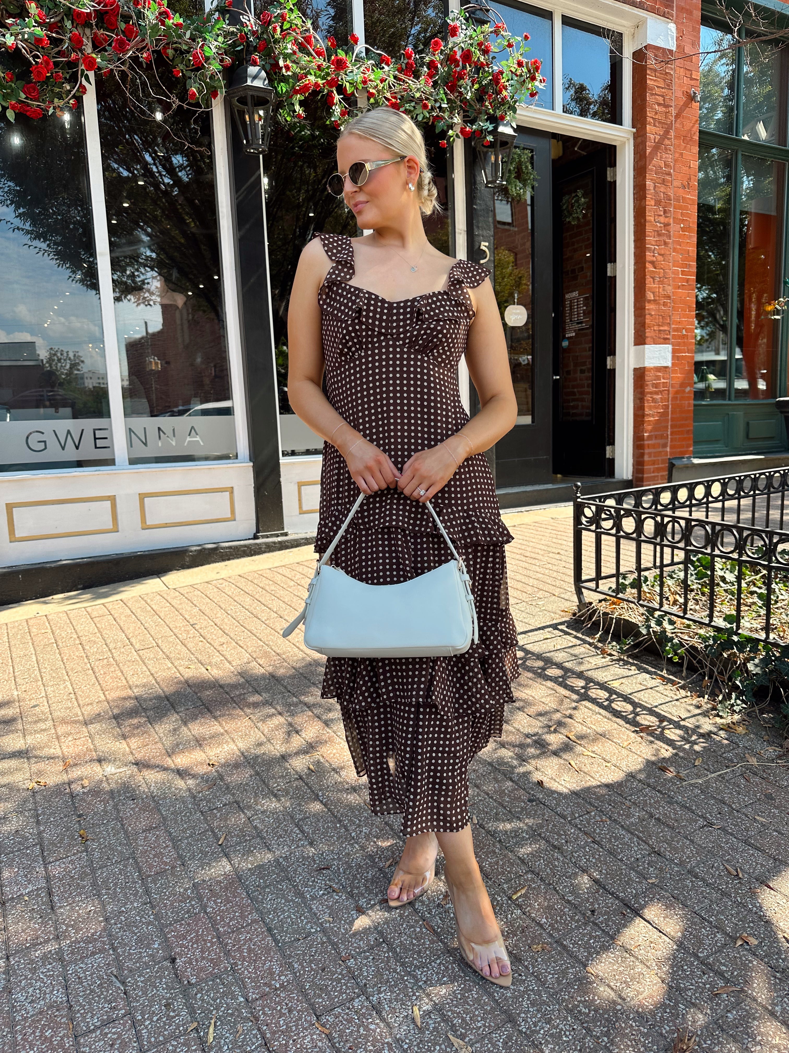 Woman wearing brown polka dot ruffle tiered midi dress. 
