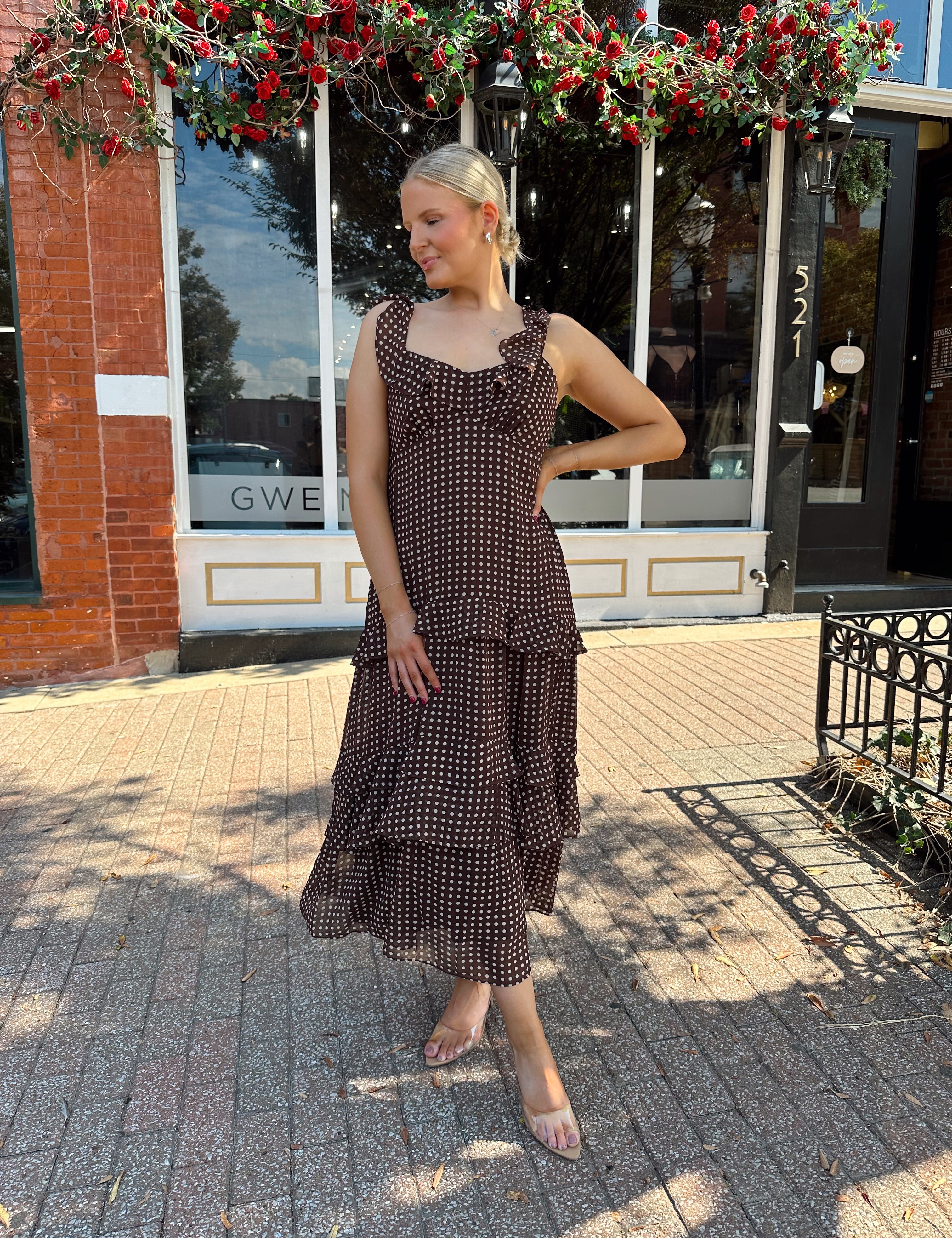 Woman wearing brown polka dot ruffle tiered midi dress. 