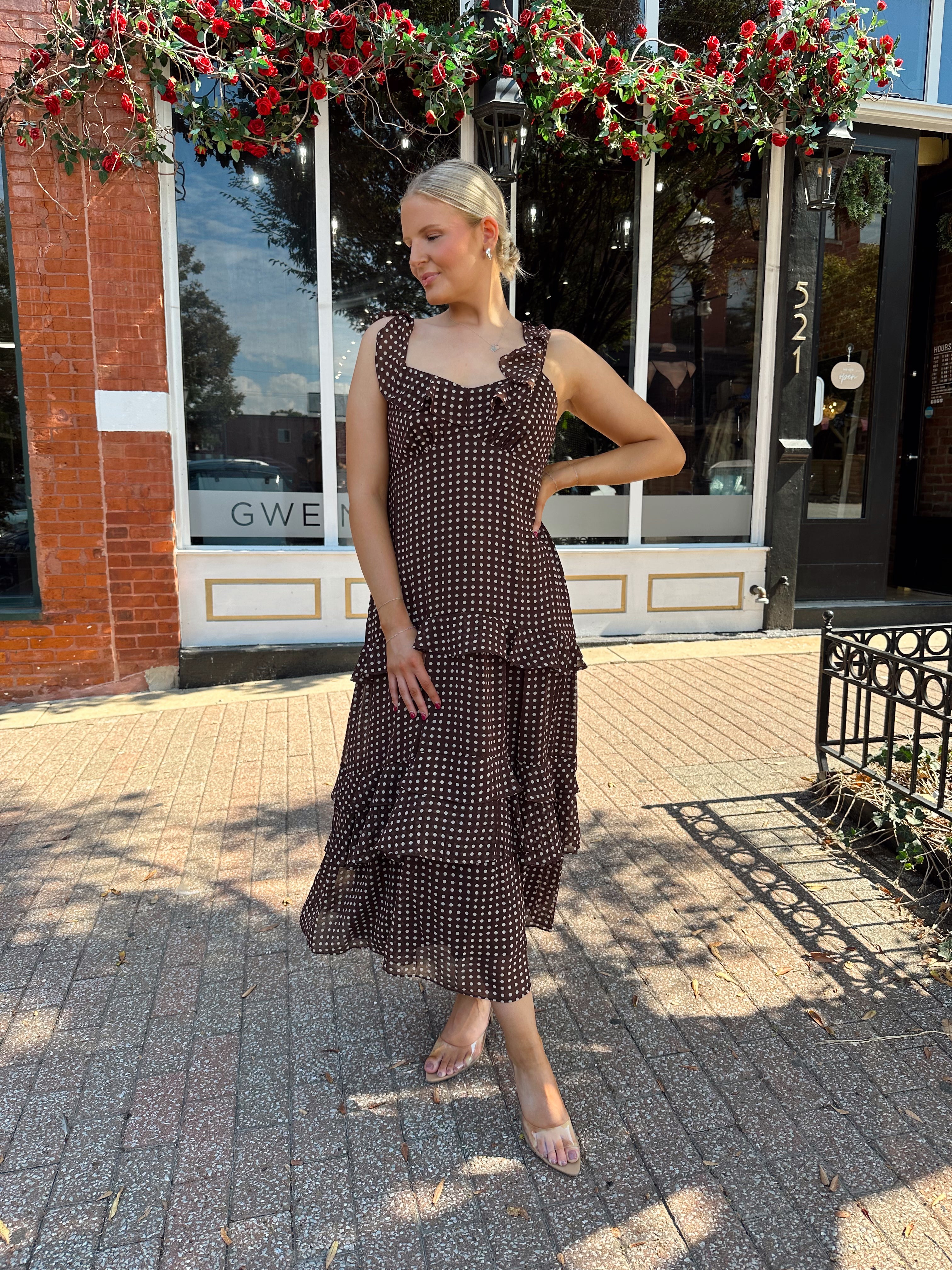 Woman wearing brown polka dot ruffle tiered midi dress. 
