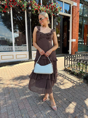 Woman wearing brown polka dot ruffle tiered midi dress. 