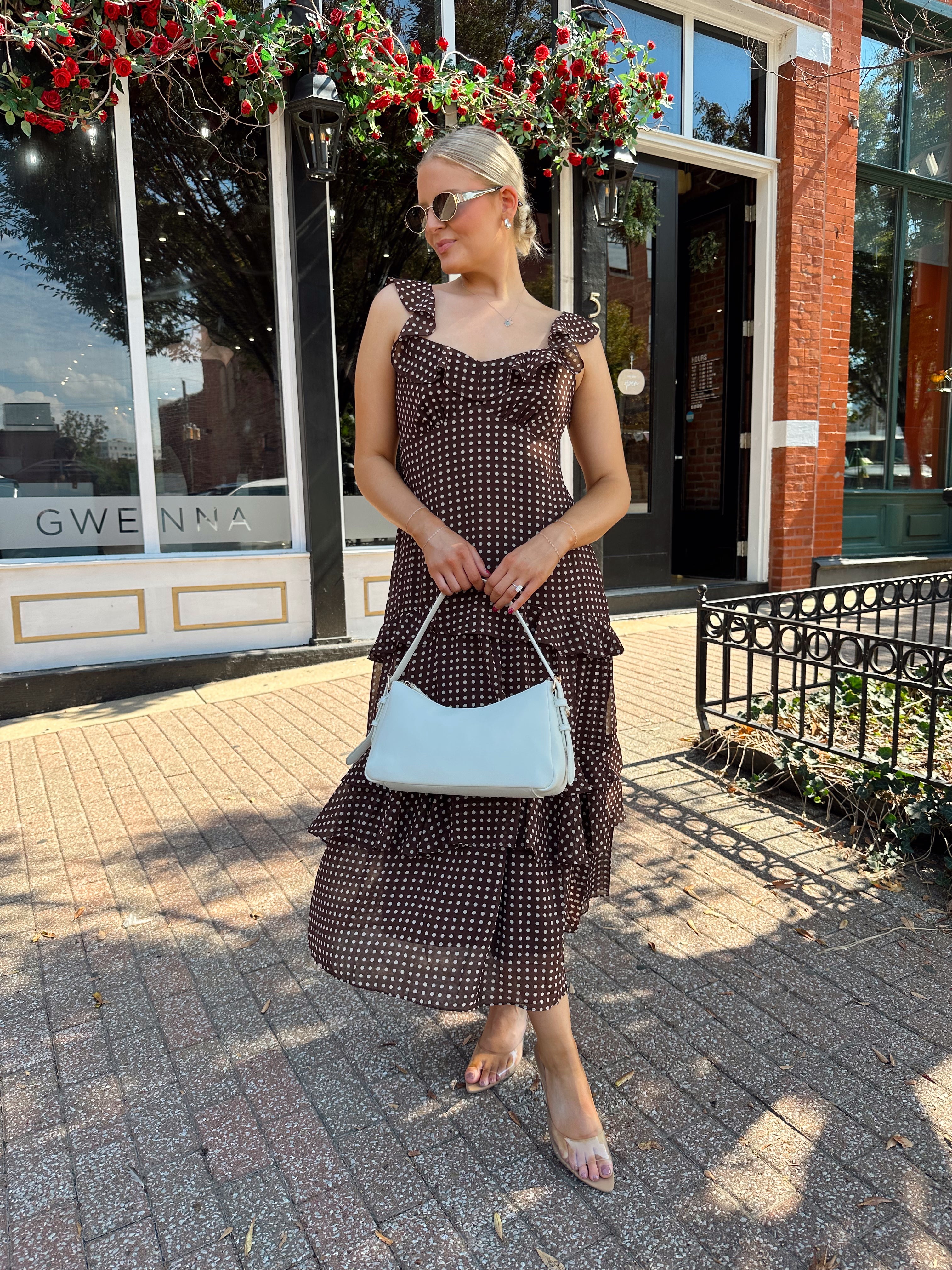 Woman wearing brown polka dot ruffle tiered midi dress. 