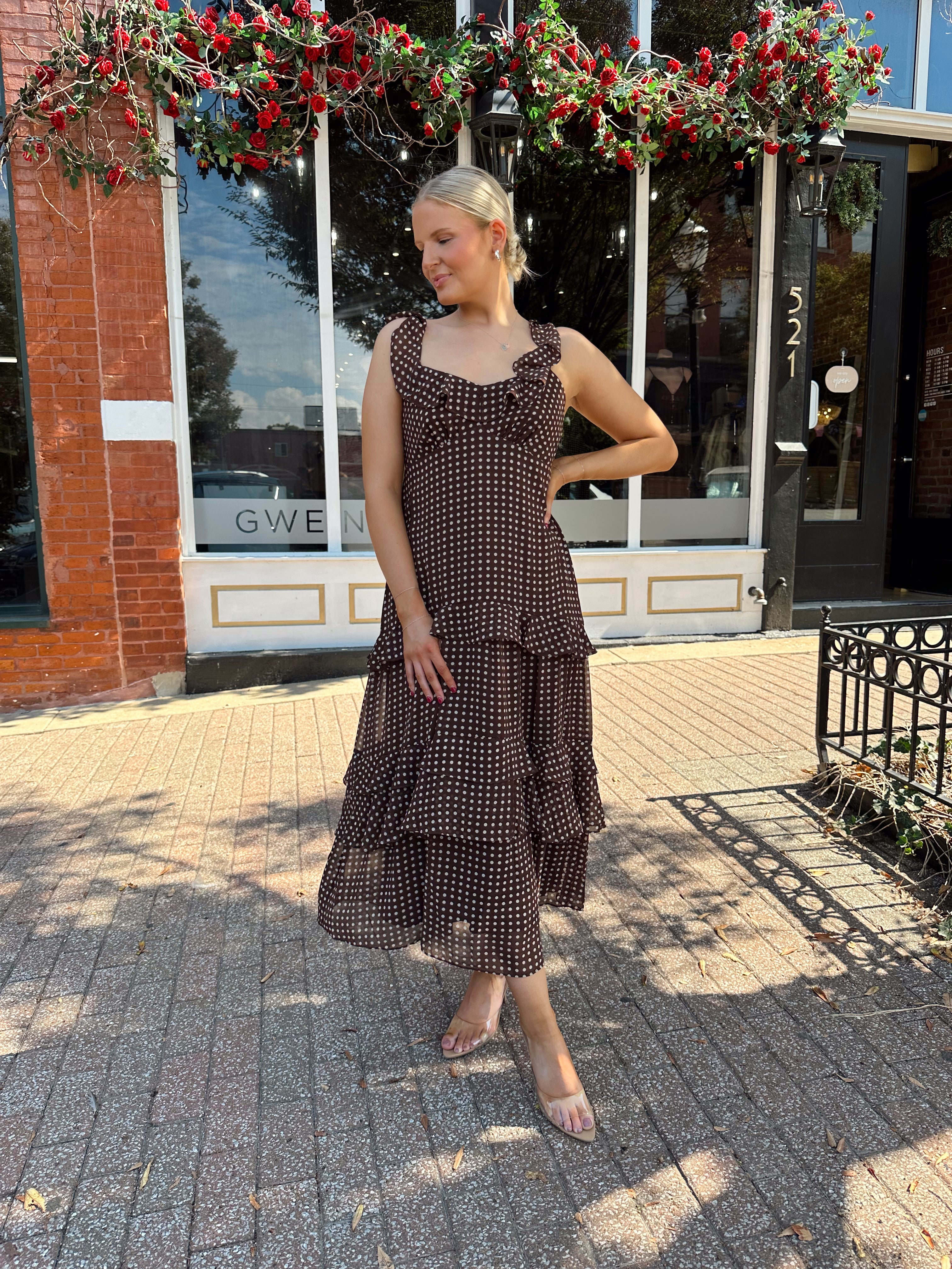 Woman wearing brown polka dot ruffle tiered midi dress. 