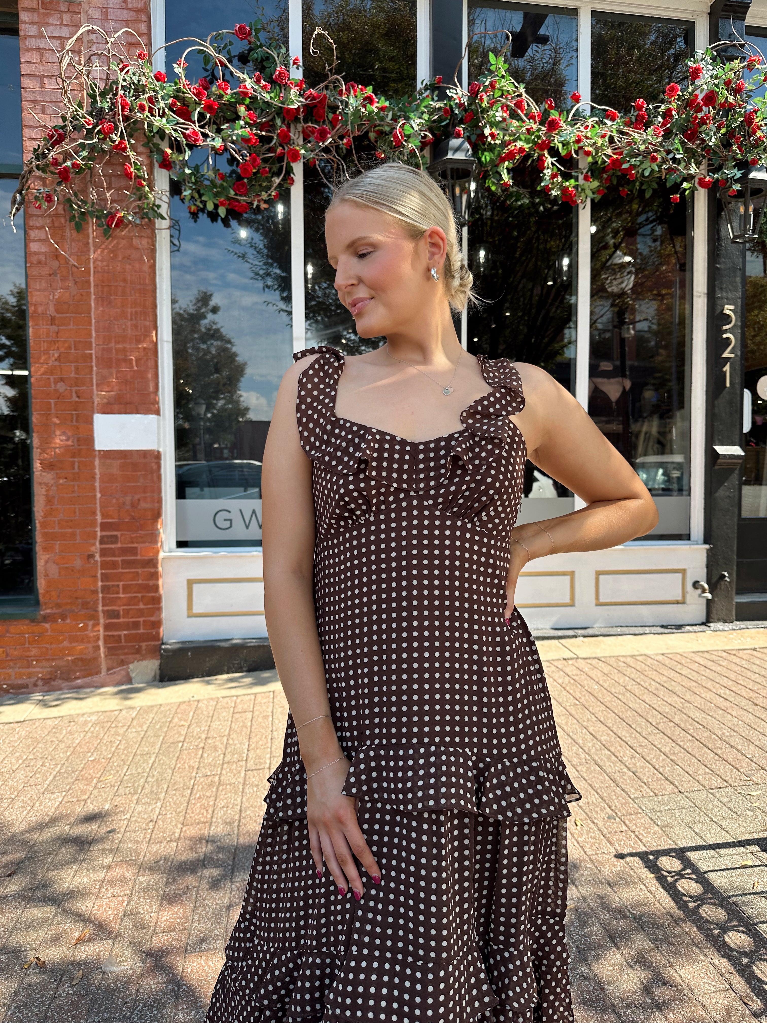 Woman wearing brown polka dot ruffle tiered midi dress. 