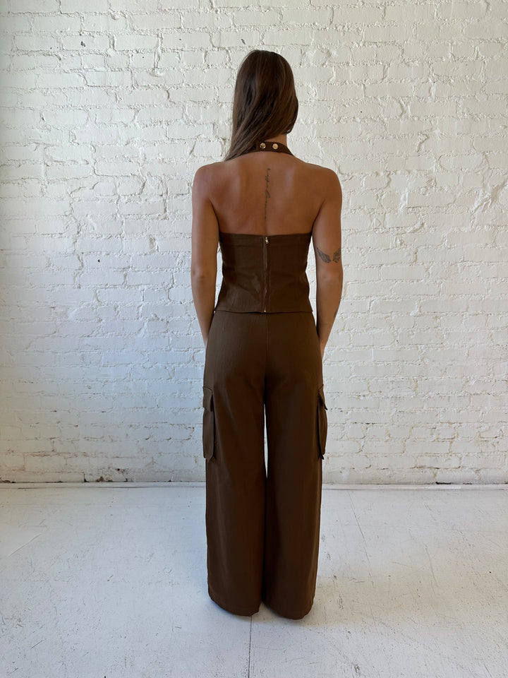 Woman wearing brown two piece cargo pant set with halter neck, and lace up front detail. 