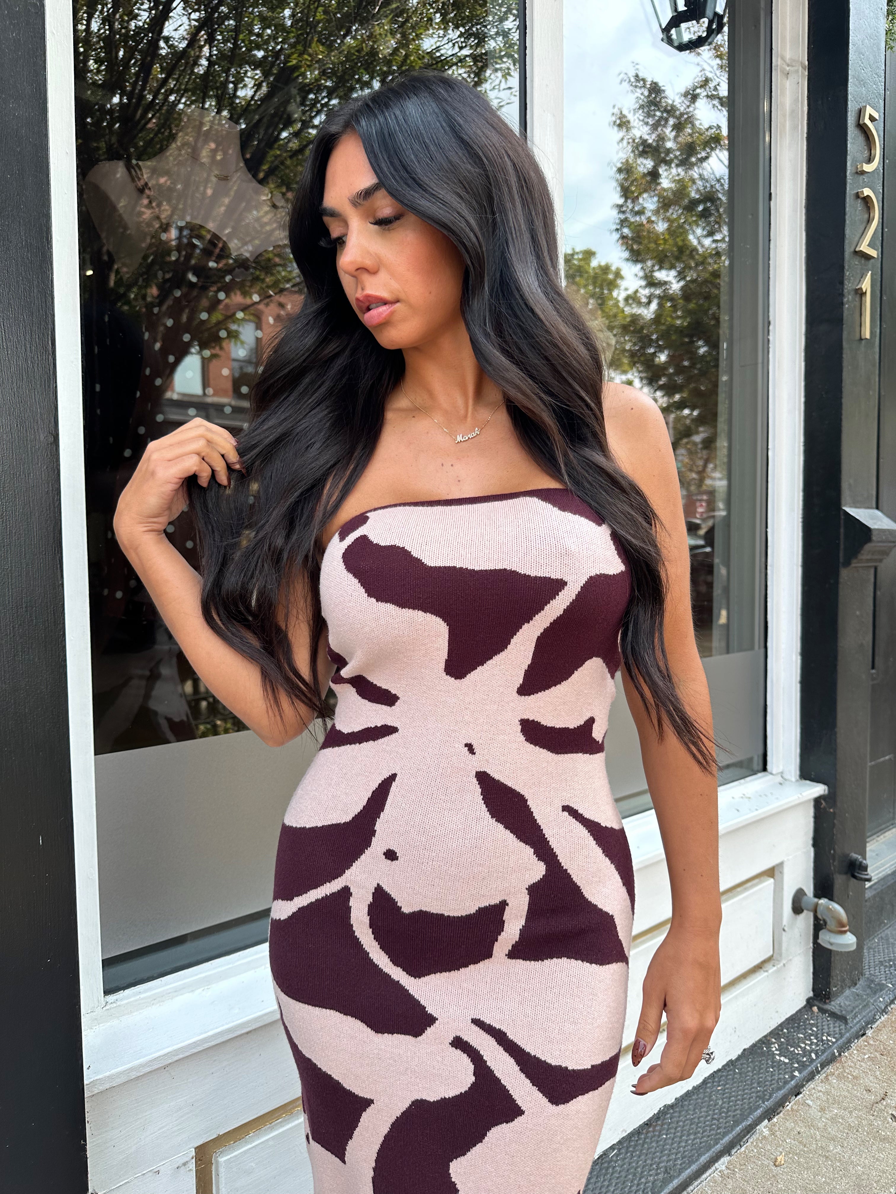 Woman wearing burgundy pattern strapless bodycon midi dress.