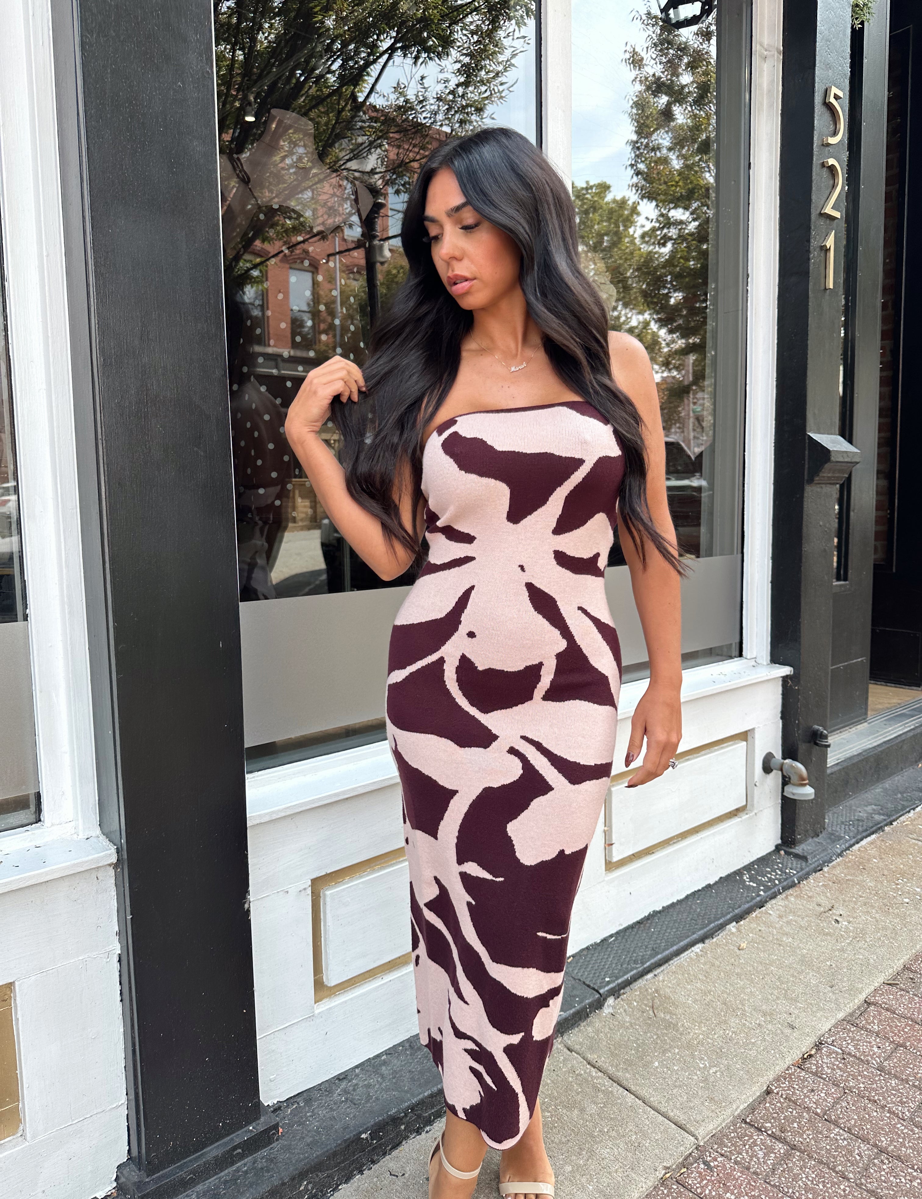 Woman wearing burgundy pattern strapless bodycon midi dress.