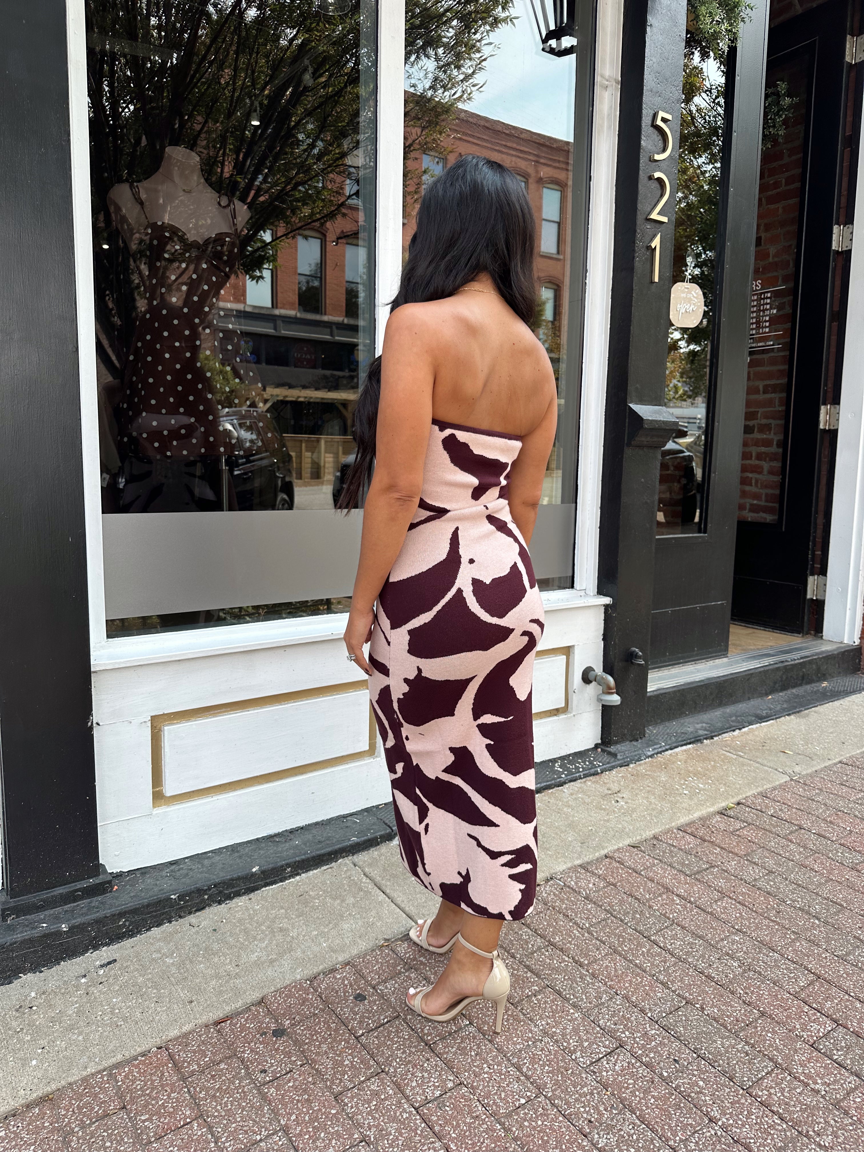 Woman wearing burgundy pattern strapless bodycon midi dress.