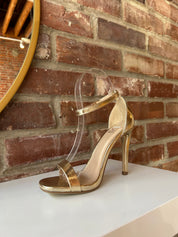 Gold metallic open toe heel with slim ankle strap and sleek stiletto heel